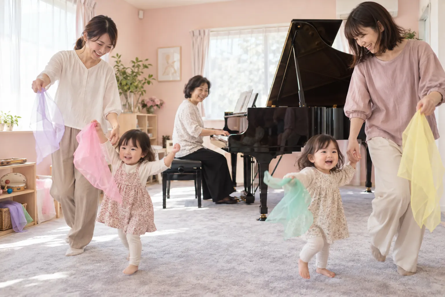 先生のグランドピアノに合わせて、親子がスカーフを持って歩く様子
